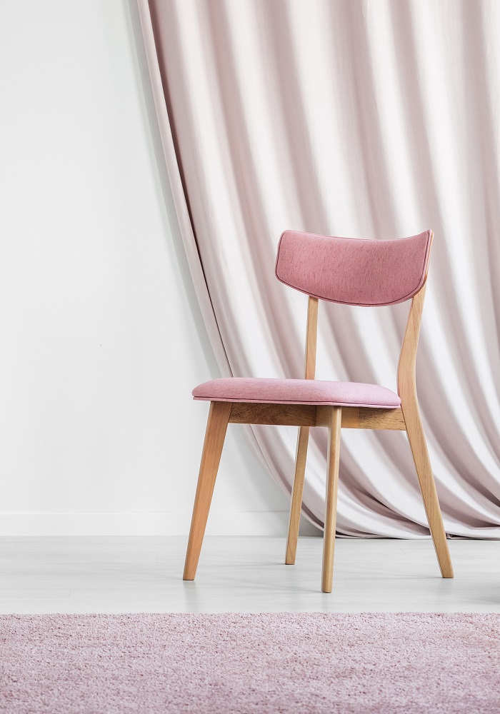 Vintage stolica sa drvenim nogama i ružičastim naslonom