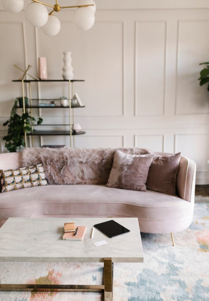 štukature, pastelni zidovi i pastelna zaobljena sofa u dnevnom boravku