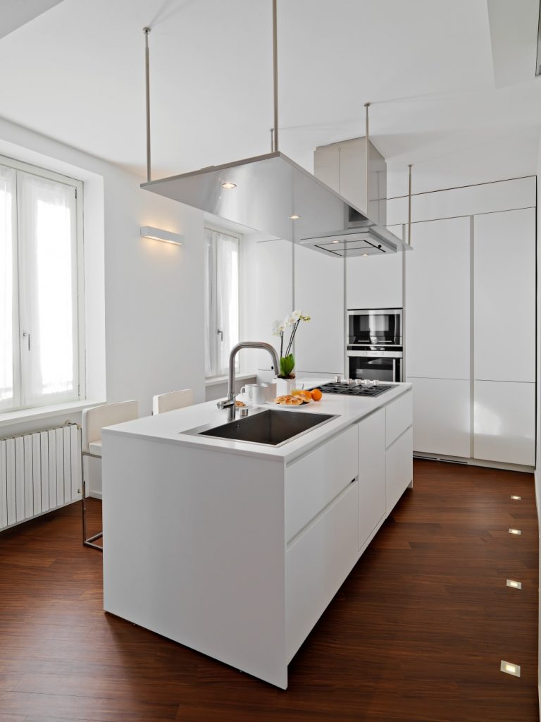 bijela kuhinja i kuhinjski otok sa sudoperom i štednjakom