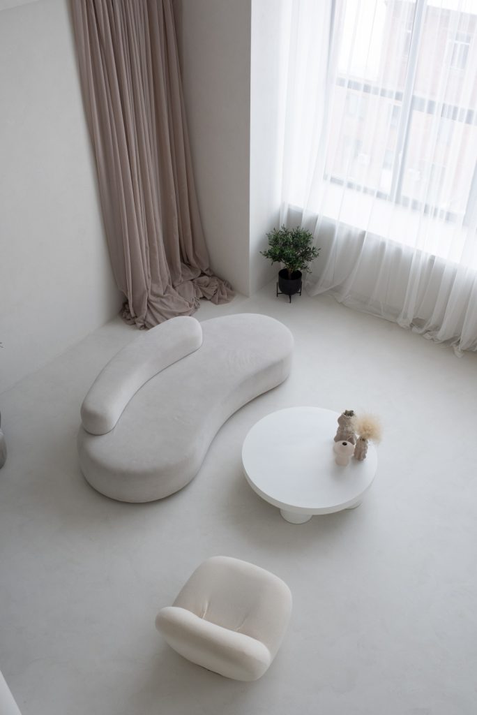 prostrana dnevna soba u bijeloj boji i okrugli stol