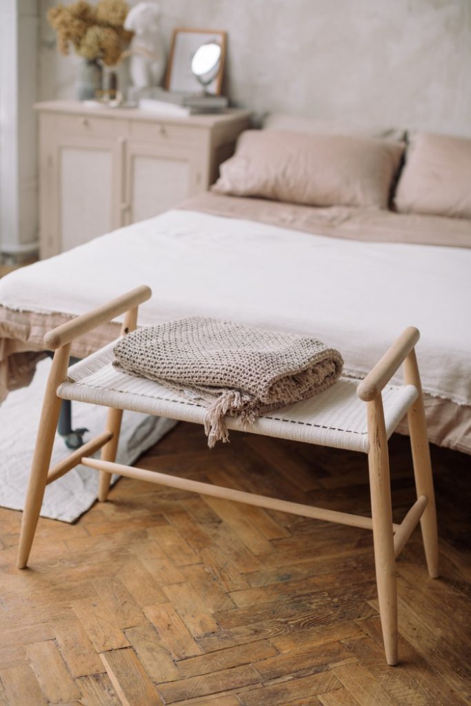 skandinavski stil uređenja u spavaćoj sobi sa klupicom i dekom